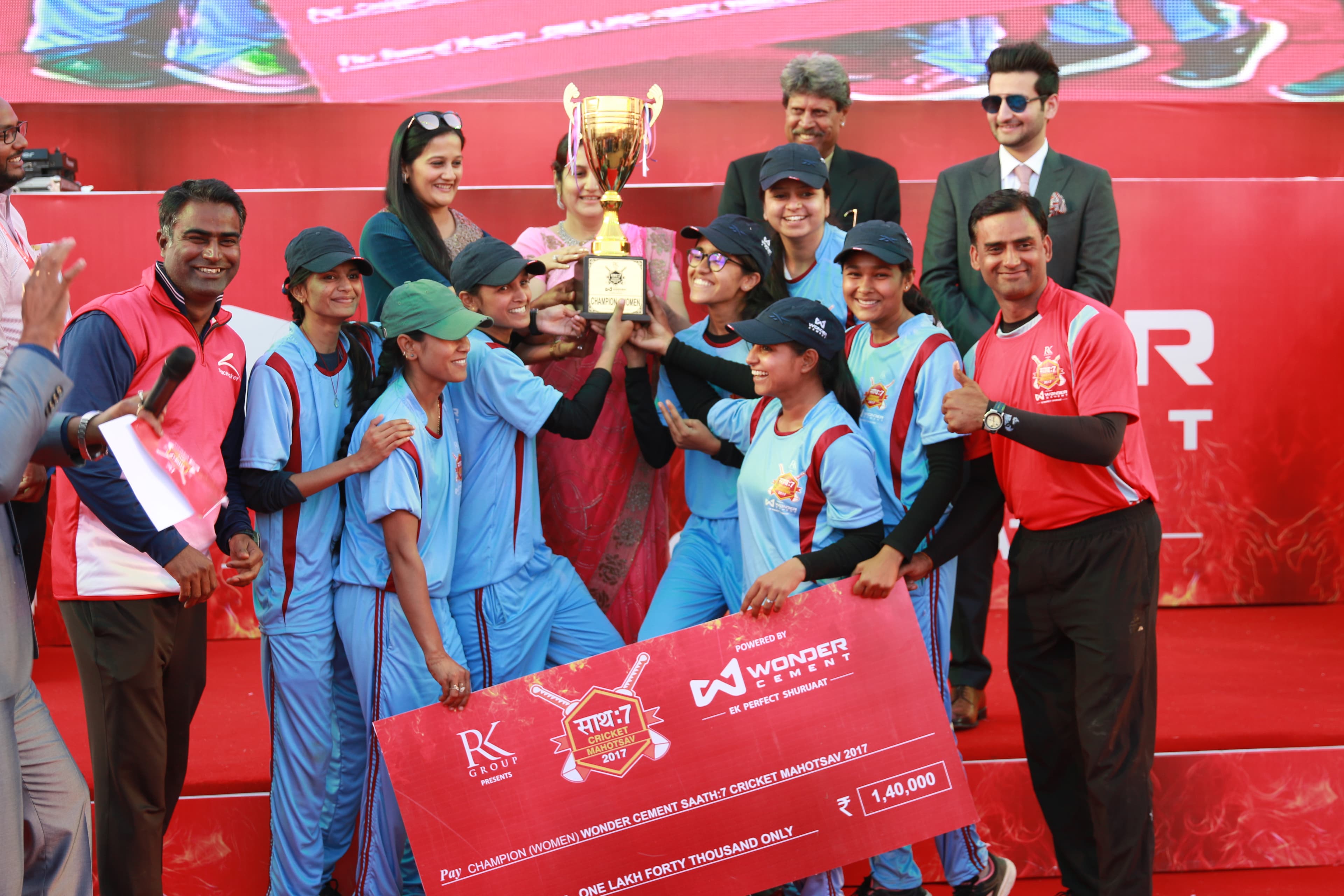 The winning women's team lifting the trophy on stage